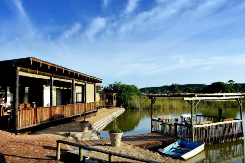 a building with a dock next to a body of water at Klein Plekkie Self Catering Accommodation in Addo