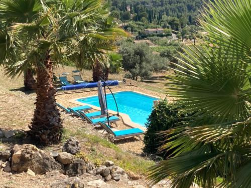 - une piscine dans un complexe avec des palmiers dans l'établissement La Venturonne Appartement neuf Rez de jardin 45 m2 vue mer et vignes 10 mn des plages, au Beausset