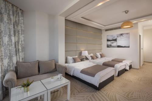 a hotel room with two beds and a couch at Miramar Boutique Hotel in Alexandria