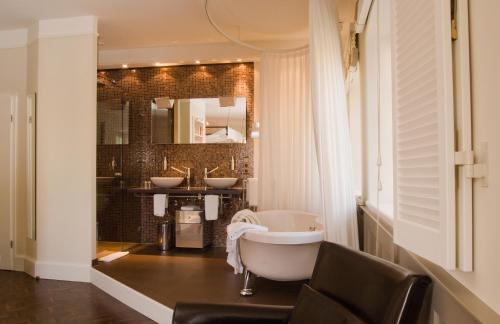 a bathroom with two sinks and a bath tub at Villa Mittermeier, Hotellerie & Restaurant in Rothenburg ob der Tauber