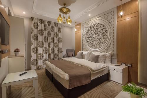 a bedroom with a large bed and a desk at Miramar Boutique Hotel in Alexandria