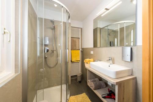 a bathroom with a shower and a sink and a mirror at Haus Claudia in Nova Levante