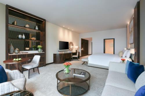 a hotel room with a bed and a living room at Sofitel Dubai The Obelisk in Dubai