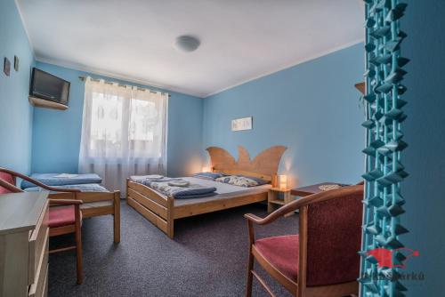 um quarto com duas camas e uma mesa e cadeiras em Penzion U Kašpárků em Žehrov