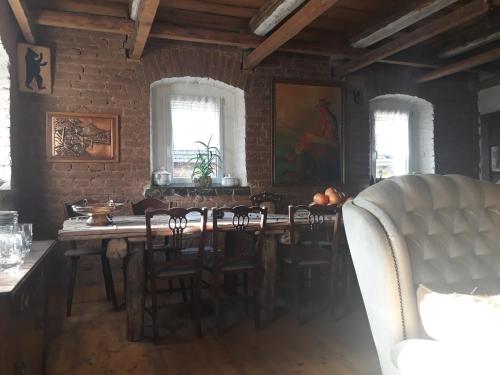 a dining room with a table and chairs and windows at Siedlisko Pod Jaworem in Domaszków