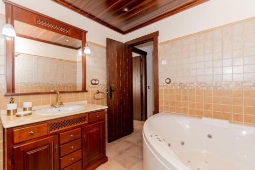 ein Badezimmer mit einer Badewanne und einem Waschbecken in der Unterkunft Cubo's Casa El Torcal in Villanueva de la Concepción
