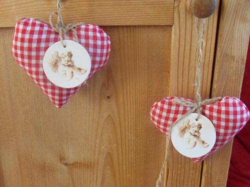 three hearts hanging on a wooden wall with checkered bows at DAS Max in Dalaas