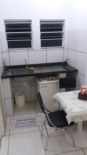 a kitchen with a desk and a chair in a room at Jóias Preciosas- Kitnet Mobiliado in Campinas