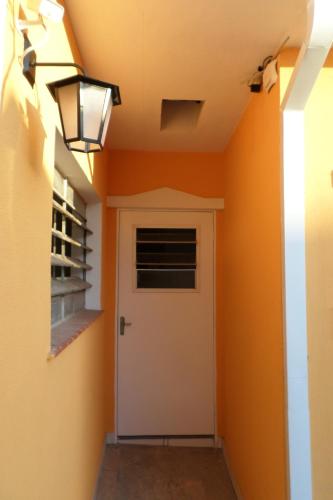 a hallway with orange walls and a door at Jóias Preciosas- Kitnet Mobiliado in Campinas