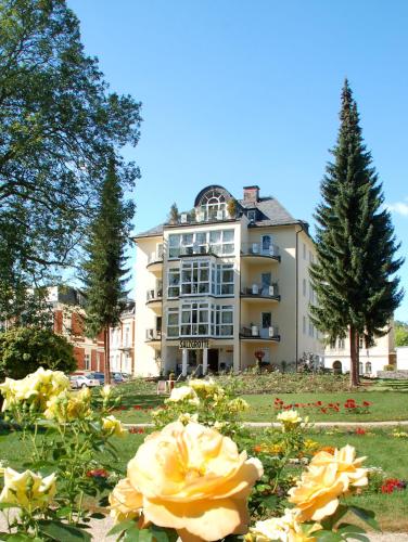 a large building with flowers in front of it at 28 qm Apartments am Rosengarten in Bad Elster