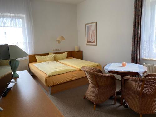 a bedroom with a bed and a table and chairs at 28 qm Apartments am Rosengarten in Bad Elster