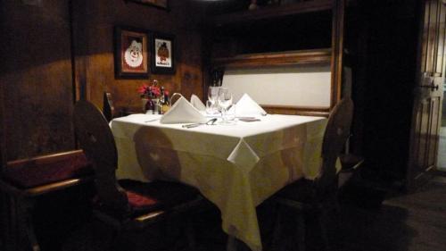 a dining room table with a white table cloth and chairs at Gasthof Eggwirt in Ultimo