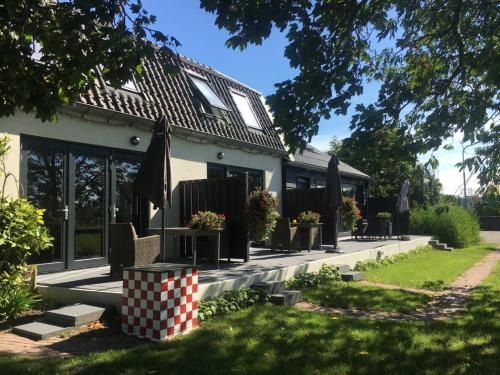 a house with a table and chairs in a yard at Mooi appartement in een prachtige fiets-wandelomgeving in Abcoude