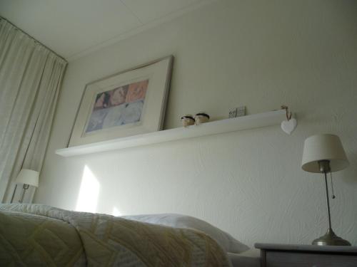 a bedroom with a bed and a shelf on the wall at Hotel Pension Oranje in Valkenburg