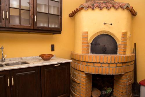 cocina con horno de ladrillo en la pared en De Felipe Casa Rural, en Horche