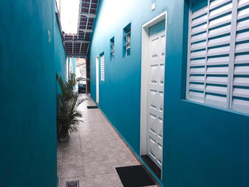 einen Flur eines Gebäudes mit blauen Wänden und Türen in der Unterkunft Mar dos Sonhos Suítes in Ubatuba