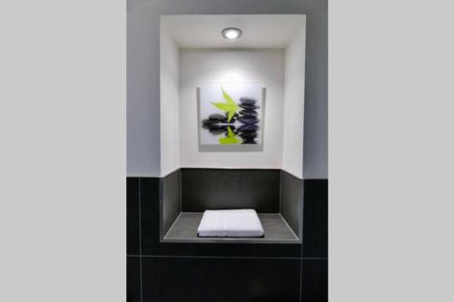 a bathroom with a white towel on a black tile floor at St Brendans Apartment in Elgin
