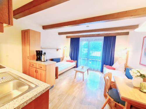 a kitchen and living room with a large window at Alpenlandhof in Bad Kleinkirchheim