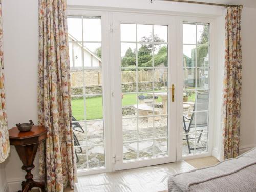 a bedroom with french doors looking out onto a garden at Bryn Celyn in Oswestry