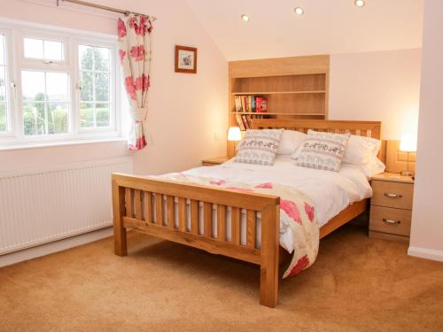 a bedroom with a bed with a bench and a window at Bryn Celyn in Oswestry