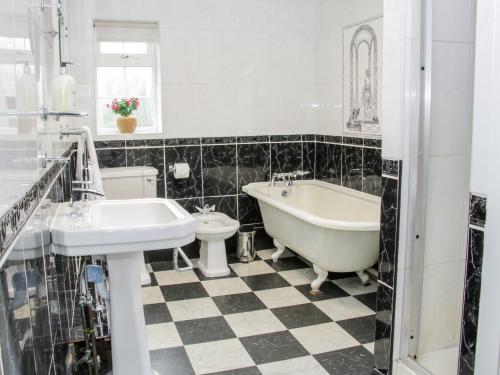 a bathroom with a tub and a sink and a toilet at Bryn Celyn in Oswestry