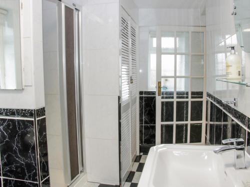 a white bathroom with a tub and a window at Bryn Celyn in Oswestry