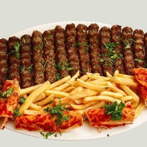 a plate of food with sausage and french fries at Daraysh Hotel in Sharjah