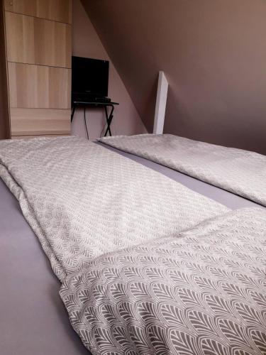 a bed with a white comforter in a bedroom at Panna tanya in Tahitótfalu