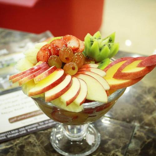 a glass bowl filled with fruit on a table at Daraysh Hotel in Sharjah