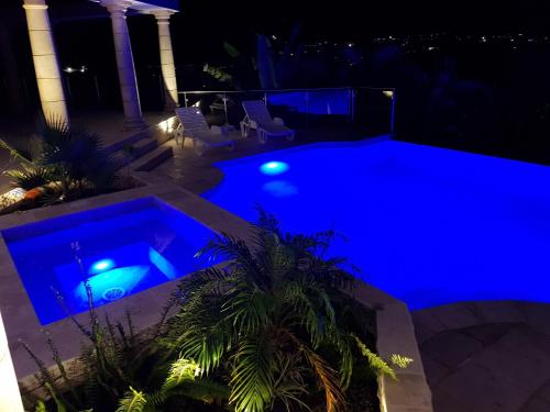 a swimming pool at night with blue lighting at C'RENITY VILLA in Cul de Sac