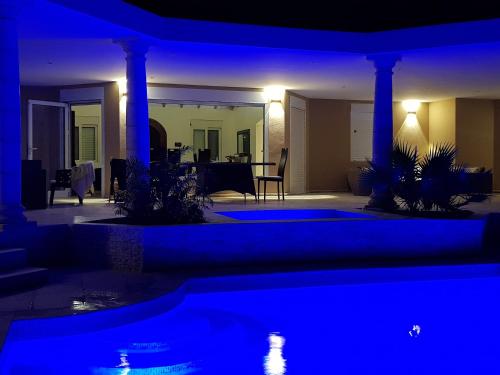 a night view of a house with blue lights at C'RENITY VILLA in Cul de Sac