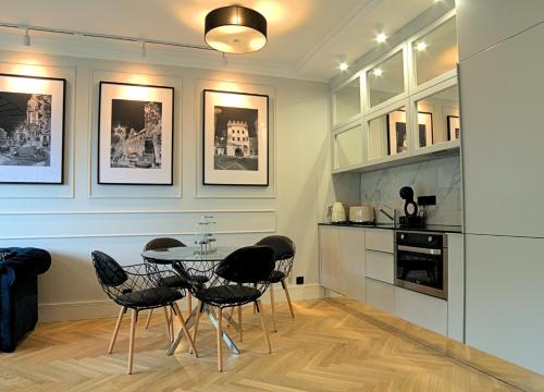 eine Küche mit einem Tisch und Stühlen im Zimmer in der Unterkunft Blue Velvet Premium Apartments III in Toruń