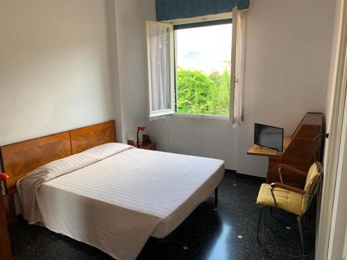 una camera con letto, scrivania e finestra di Albergo Magenta a Casella