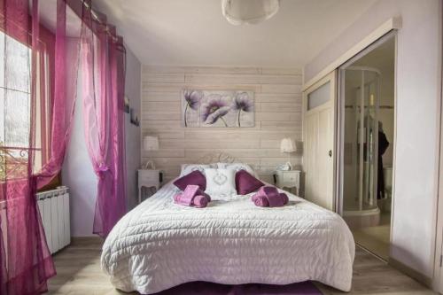 a bedroom with a large white bed with pink pillows at Gite l'Ecoline 5 étoiles Isère 113m2 6 pers vue satellite piscine in Brion