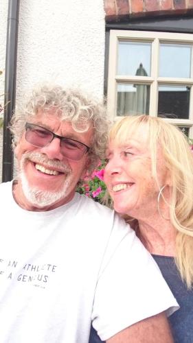 a man and a woman standing in front of a house at The Old Post Office B&B in Lymm