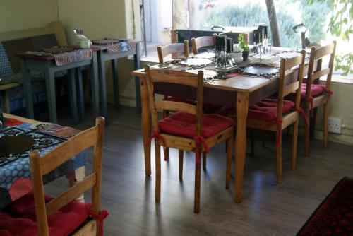 een houten eettafel met stoelen en een tafel bij Homestead Guesthouse and Coffee Shoppe in Sasolburg