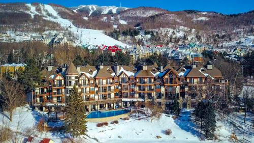a small town with a mountain range and ski lodge at Hotel Quintessence in Mont-Tremblant