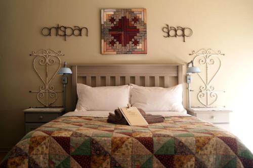 a bedroom with a bed with a book on it at Homestead Guesthouse and Coffee Shoppe in Sasolburg