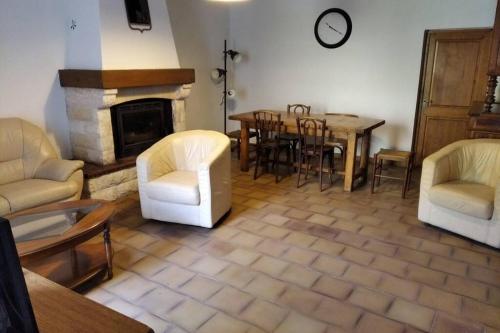 sala de estar con chimenea, mesa y sillas en Gîte en Cévennes, en Sumène