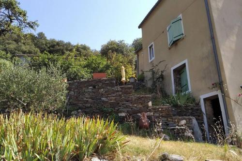 a house with a stone wall next to a building at Gîte en Cévennes in Sumène
