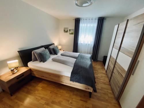 een slaapkamer met een groot bed en een houten vloer bij Luxuriöses und modernes Apartment zum Wohlfühlen in Zirl
