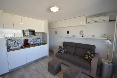 un salon avec un canapé et une cuisine dans l'établissement STUDIO VUE PORT ET MER, à Valras-Plage