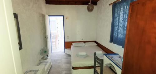 a small bedroom with a bed and a bathroom at Oleander's Garden Traditional Cretan Cottage in Ferma