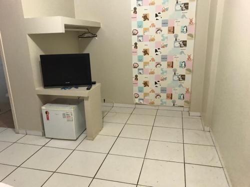a room with a door with a television and a tiled floor at Carol Palace Hotel in Foz do Iguaçu