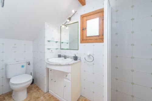 uma casa de banho com um WC, um lavatório e um espelho. em Villa YESERO em Pollença