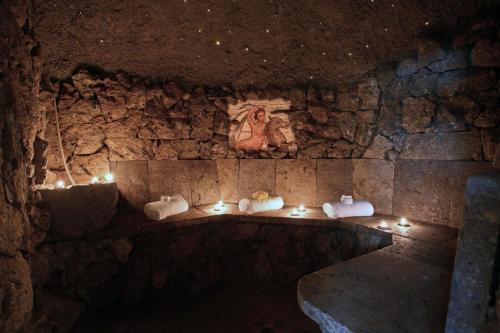 a room with a stone wall with lights on it at Grand Hotel Gortani in Arta Terme