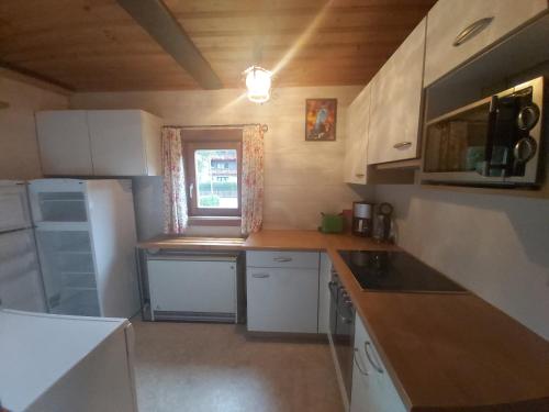 a small kitchen with white appliances and a window at Boahäusl in Flachau