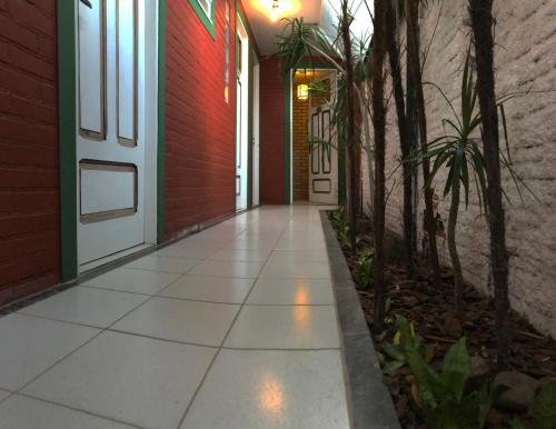 a walkway leading to a door in a building at Pousada Canoa Azul na Praia da Ferrugem in Garopaba