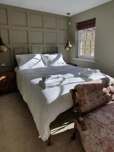 a bedroom with a large bed with towels on it at Stylish Stamford Central, Free Parking in Stamford