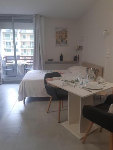 une chambre avec un lit, un bureau et une table dans l'établissement A la montagne à 2 App107, à Cauterets